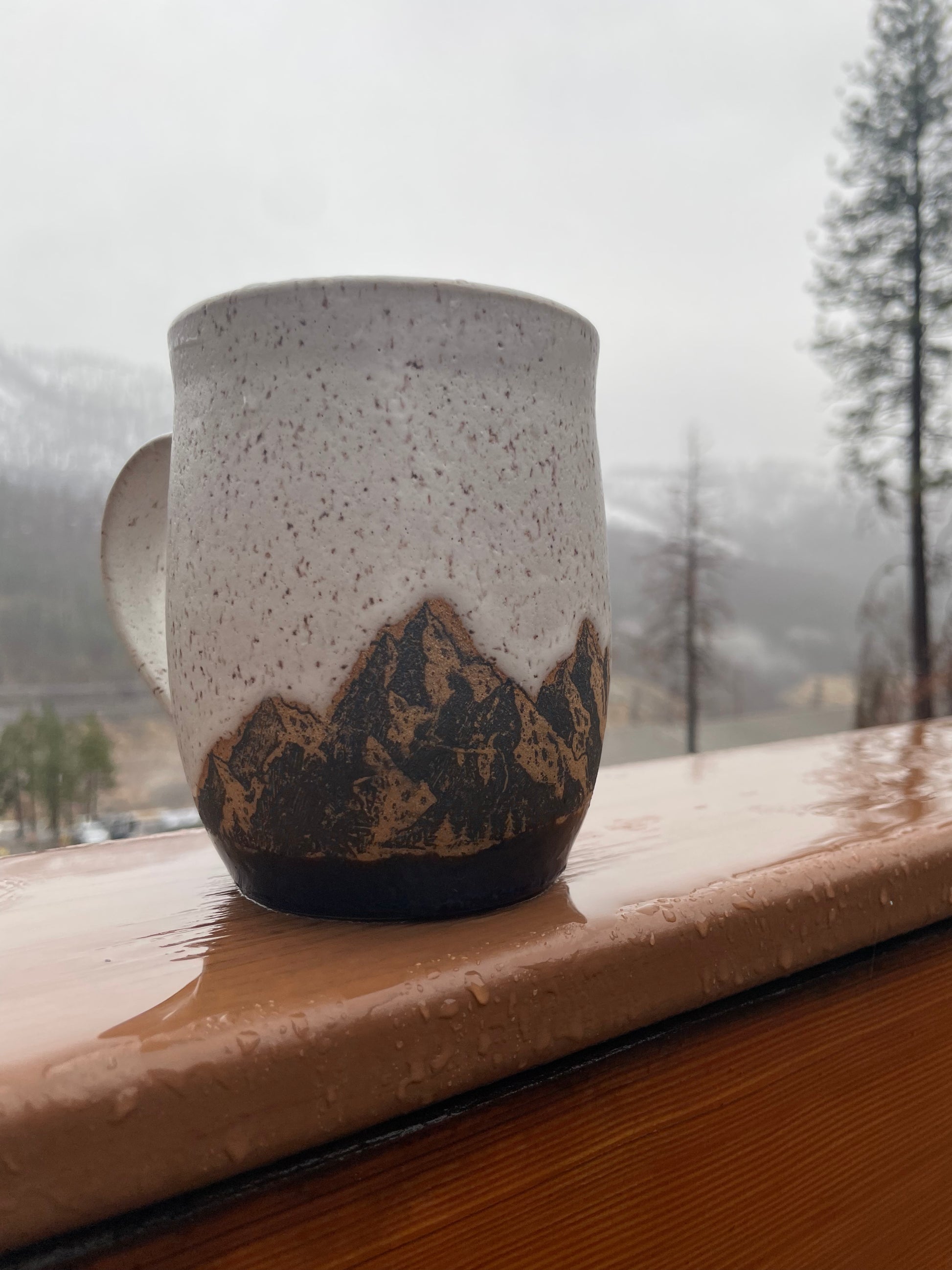 Close up of mountain range coffee cup on a rainy morning.